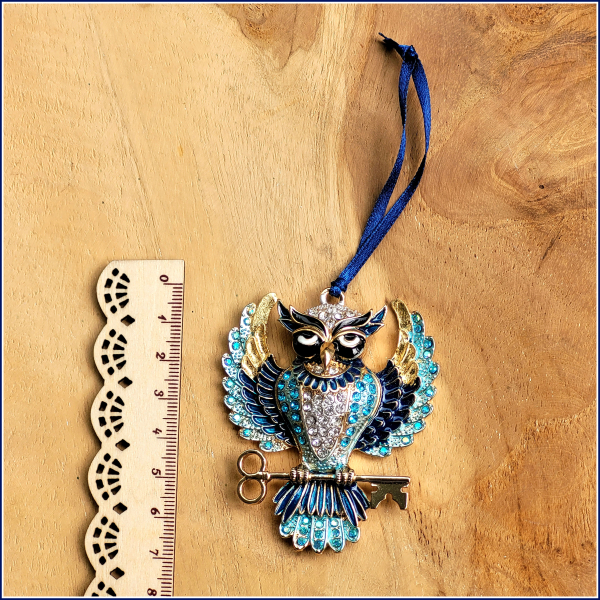 Geschenk-, Deko- oder Baumanhänger „Funkelnde Eule mit Schlüssel in Blau“ mit Blattmetall verziert, an dunkelblauem Satinband