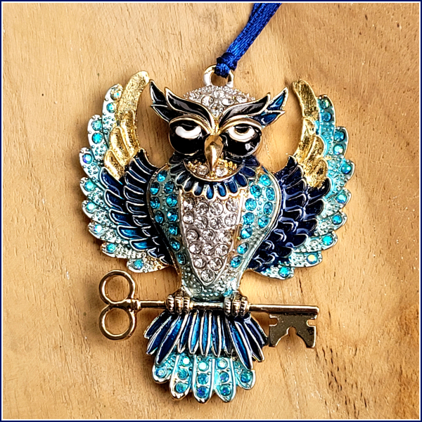 Geschenk-, Deko- oder Baumanhänger „Funkelnde Eule mit Schlüssel in Blau“ mit Blattmetall verziert, an dunkelblauem Satinband